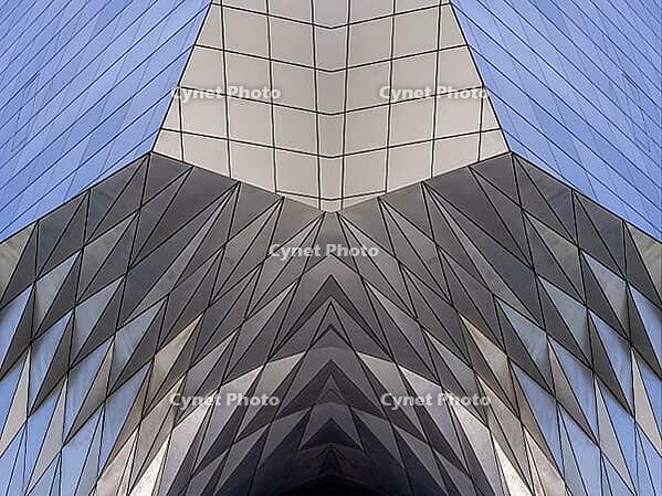 Abstract photography with a symmetrical, diamond-shaped shape that consists of repetitive lines and surfaces in shades of gray, white and blue and creates an impression of rhythm, depth and cool geometric harmony [IBR123760821]