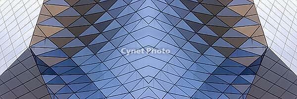 Abstract photography with a symmetrical, crystalline form, consisting of intertwined diamond-shaped surfaces in shades of blue, gray and subtle brown, which create a sense of depth, structure and cool architectural dynamism [IBR123760828]