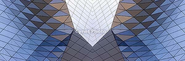 Abstract photography with a symmetrical, crystalline form, consisting of intertwined diamond-shaped surfaces in shades of blue, gray and subtle brown, which create a sense of depth, structure and cool architectural dynamism [IBR123760836]
