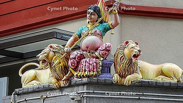 An armed figure on a temple flanked by two lions in colorful depiction, Singapore, Singapore [IBR123769643]