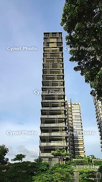An innovative skyscraper rises, flanked by more buildings and green trees, Singapore, Singapore [IBR123769657]