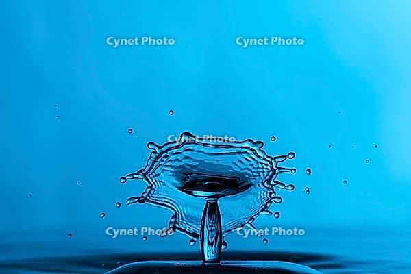 Clear blue water droplet splash over blue background [IBR123878832]