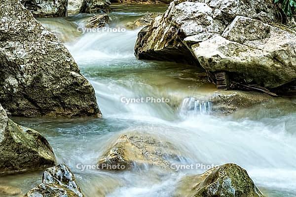 Raging clean fresh mountain river flowing between rocks [IBR123878900]