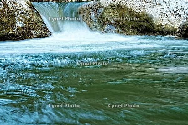 Raging clean fresh mountain river flowing between rocks [IBR123878901]