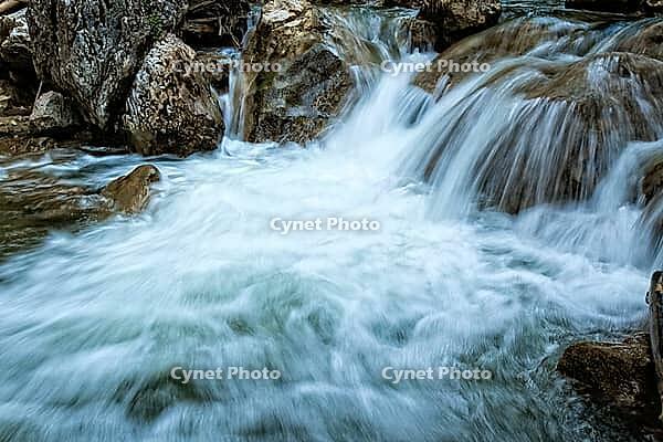 Raging clean fresh mountain river flowing between rocks [IBR123878911]