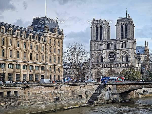 Paris, France - December 10, 2025: The iconic Notre-Dame Cathedral on the Seine riverbank. Tall construction crane stands beside the gothic towers, highlighting the restoration of the famous landmark [IBR123895586]