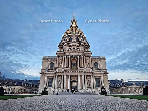 Stunning exterior view of the gilded Dome des Invalides in Paris, France. The cobblestone courtyard and the Saint-Louis Cathedral at dusk. Monumental Baroque architecture [IBR123895593]