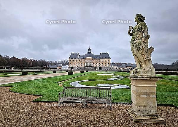 Maincy, France - December 11, 2025: Majestic Chateau de Vaux-le-Vicomte with view from the garden. Gravel paths with symmetrical manicured hedges, and antique classical statues of baroque masterpiece [IBR123895600]