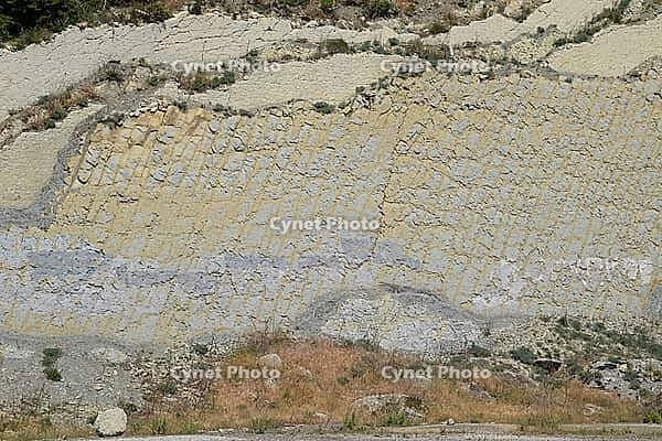 Slope of the mountain with layers of sedimentary rocks. Vertically located sedimentary rocks on a collapsing hillside. Novorossiysk, Russia [IBR123911554]