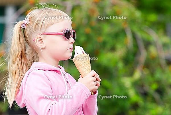 Little girl eating icecream [IBR123980442]