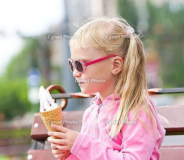Little girl eating icecream [IBR123980447]