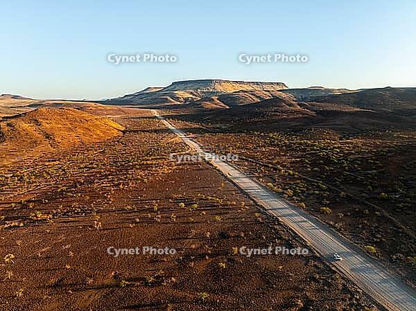 Aerial view, road leading through dry desert landscape, hills in Damaraland, Namibia [IBR123990968]