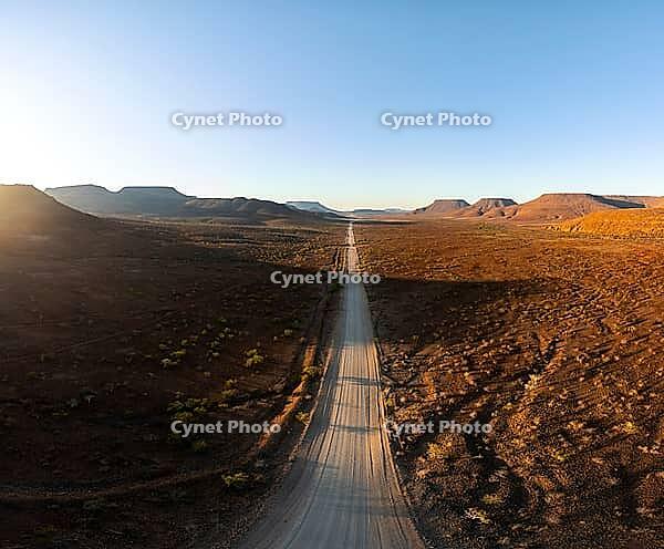 Aerial view, infinite space, straight road leads through dry desert landscape, hills in Damaraland, Namibia [IBR123990969]