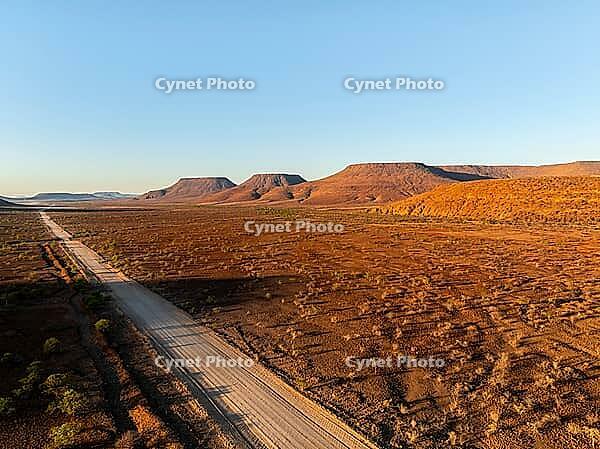 Aerial view, road leading through dry desert landscape, hills in Damaraland, Namibia [IBR123990970]