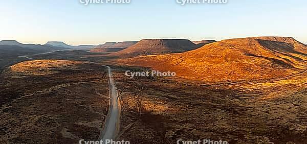 Aerial view, road leading through dry desert landscape, hills in Damaraland, Namibia [IBR123990973]