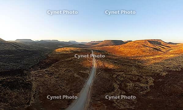 Aerial view, road leading through dry desert landscape, hills in Damaraland, Namibia [IBR123990978]