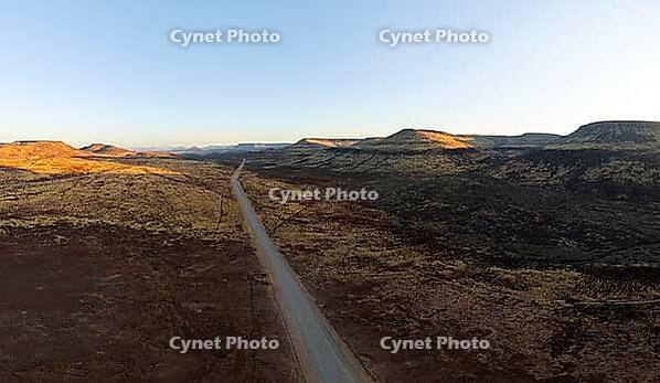 Aerial view, road leading through dry desert landscape, hills in Damaraland, Namibia [IBR123990979]