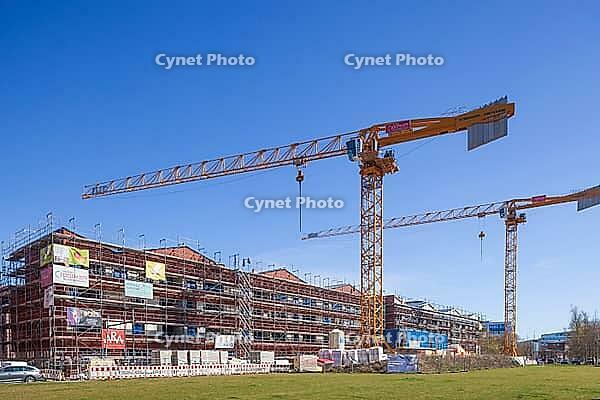 Shell of residential buildings with construction cranes in the Überseestadt of Bremen, scaffolding, construction site, Bremen [IBR123999829]