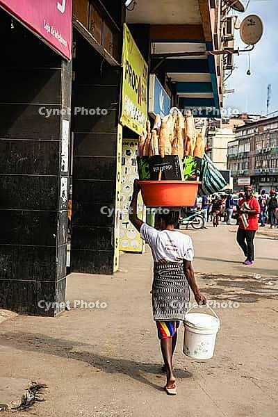 Woman carrying baguettes on her head, Luanda, Angola [IBR123999872]