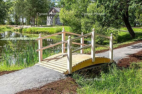 Small wooden bridge with railings at the park in summer sunny day [IBR124036445]