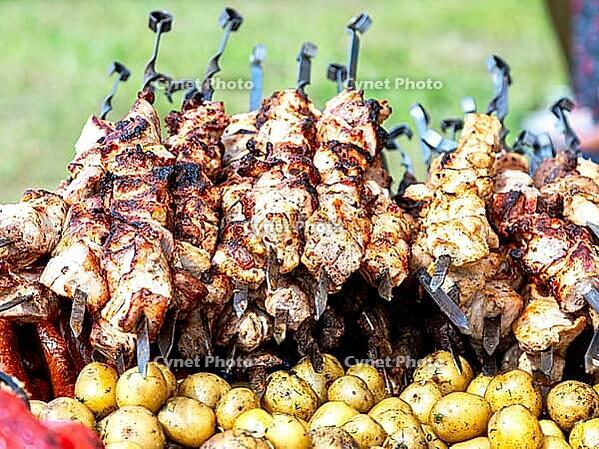 Cooking traditional appetizing hot shish kebab or shashlik on metal skewers [IBR124036453]