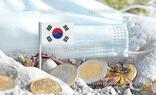 South Korea flag with euro currency coins and a medical mask on rocky ground.International healthcare costs, cross-border medical funding, Europe and Korean cooperation and global health finance [IBR124084104]
