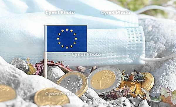 European Union flag with euro currency coins and a medical mask on rocky ground.Eurozone healthcare costs, medical funding challenges and the financial weight of modern services connected to EU [IBR124084114]