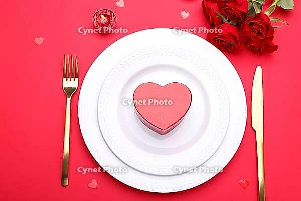 Romantic table setting, gold cutlery on the red table cloth. Valentine's day celebration [IBR124084185]