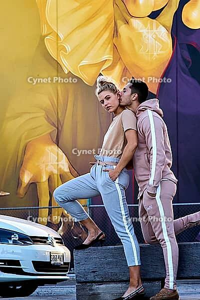 Seductive, sexy love next to parked car, lust of desireful lovers by colorful mural, depicting a close and intimate moment, sensuality, sexy, togetherness, hoodie, swag, coolness, cool, casual clothes, breeze, breezy love, emotion, bond, couple, relations [IBR124192787]