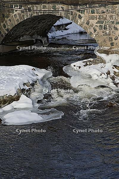 The ruins of the historic Borgvik Ironworks. Industrial stone architecture on a river in winter with snow and blue skies. Cultural heritage site in picturesque countryside in Värmland, Sweden [IBR124200524]