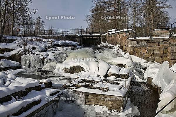 The ruins of the historic Borgvik Ironworks. Industrial stone architecture on a river in winter with snow and blue skies. Cultural heritage site in picturesque countryside in Värmland, Sweden [IBR124200525]