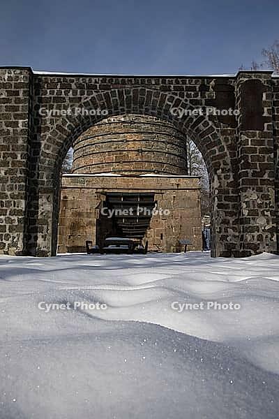 The ruins of the historic Borgvik Ironworks. Industrial stone architecture on a river in winter with snow and blue skies. Cultural heritage site in picturesque countryside in Värmland, Sweden [IBR124200530]