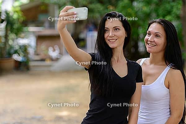 Portrait of two beautiful women together in the streets outdoors [IBR124308996]