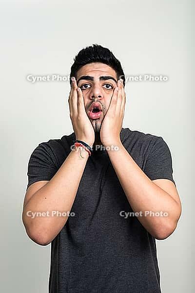 Studio shot of young handsome bearded Indian man against white background [IBR124309003]
