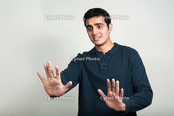 Studio shot of young handsome Indian man against white background [IBR124309008]