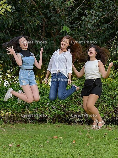 Portrait of three young Asian women as friends together relaxing at the park outdoors [IBR124309016]