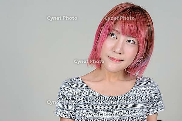 Studio shot of young beautiful Asian woman with pink hair against white background [IBR124309031]