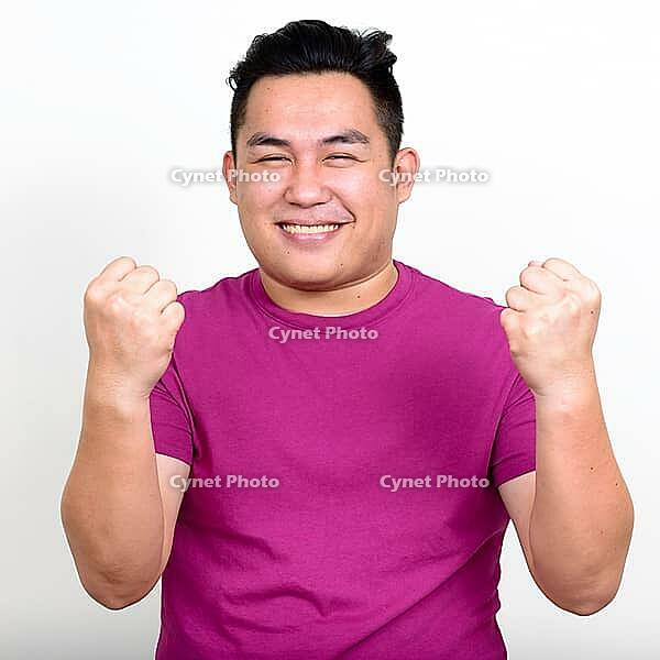 Studio shot of young handsome overweight Filipino man against white background [IBR124309033]