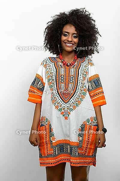Studio shot of young beautiful African woman with Afro hair wearing traditional clothes against white background [IBR124309039]