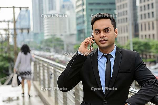 Portrait of young handsome Indian businessman in the city [IBR124309042]