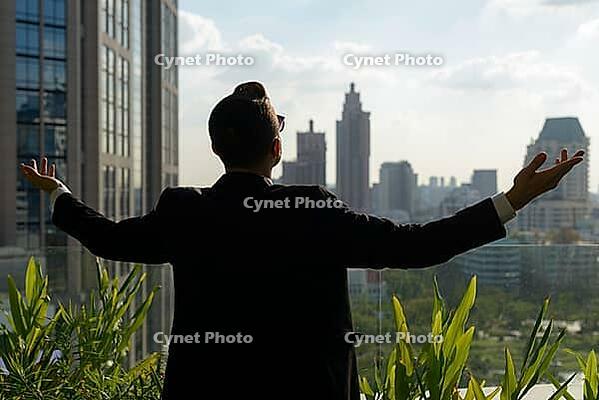 Portrait of handsome bearded Hispanic businessman with nature in the city outdoors [IBR124309047]