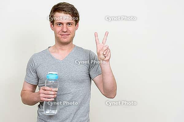 Studio shot of young handsome Scandinavian man ready for gym against white background [IBR124309054]