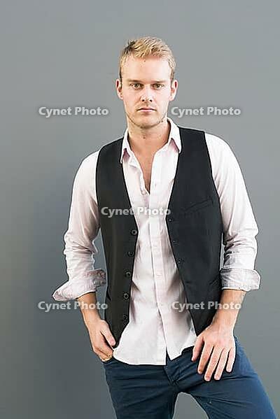 Portrait of young handsome businessman with blond hair against gray background [IBR124309056]