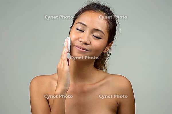 Studio shot of young beautiful Asian woman shirtless as health and beauty concept against white background [IBR124309063]