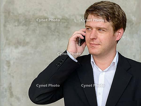 Portrait of young handsome Scandinavian businessman against concrete wall in the city outdoors [IBR124309068]