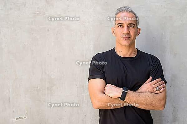 Portrait of handsome Persian man with gray hair against concrete wall outdoors [IBR124309081]