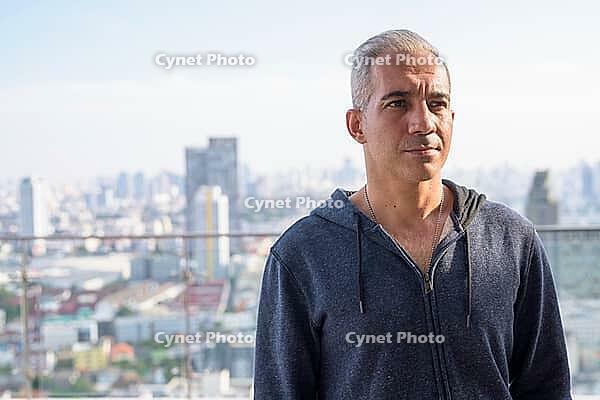 Portrait of handsome Persian man with gray hair against view of the city [IBR124309086]