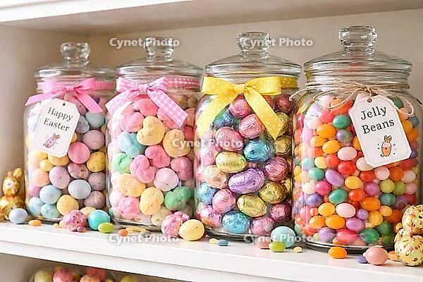 Festive glasses full of colorful Easter candy, decorated with signs and bows, pastel candy, AI generated [IBR124458849]