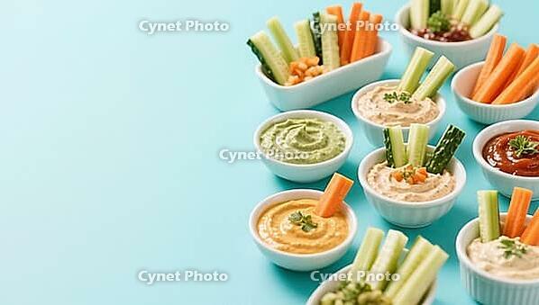 Various dips in bowls with fresh vegetables on a blue background, delicious dip, perfect as a side dish for meals and parties, AI generated [IBR124458864]