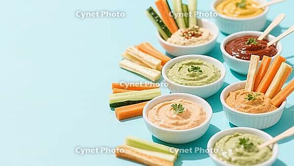 Various dips in small bowls accompanied by colorful vegetable sticks on a light blue background, delicious dip, perfect as a side dish for meals and parties, AI generates, AI generated [IBR124458877]